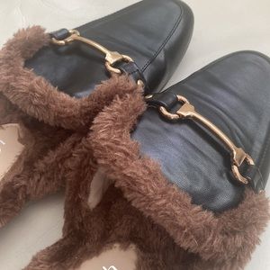 Black loafers with gold accent and brown furry detail